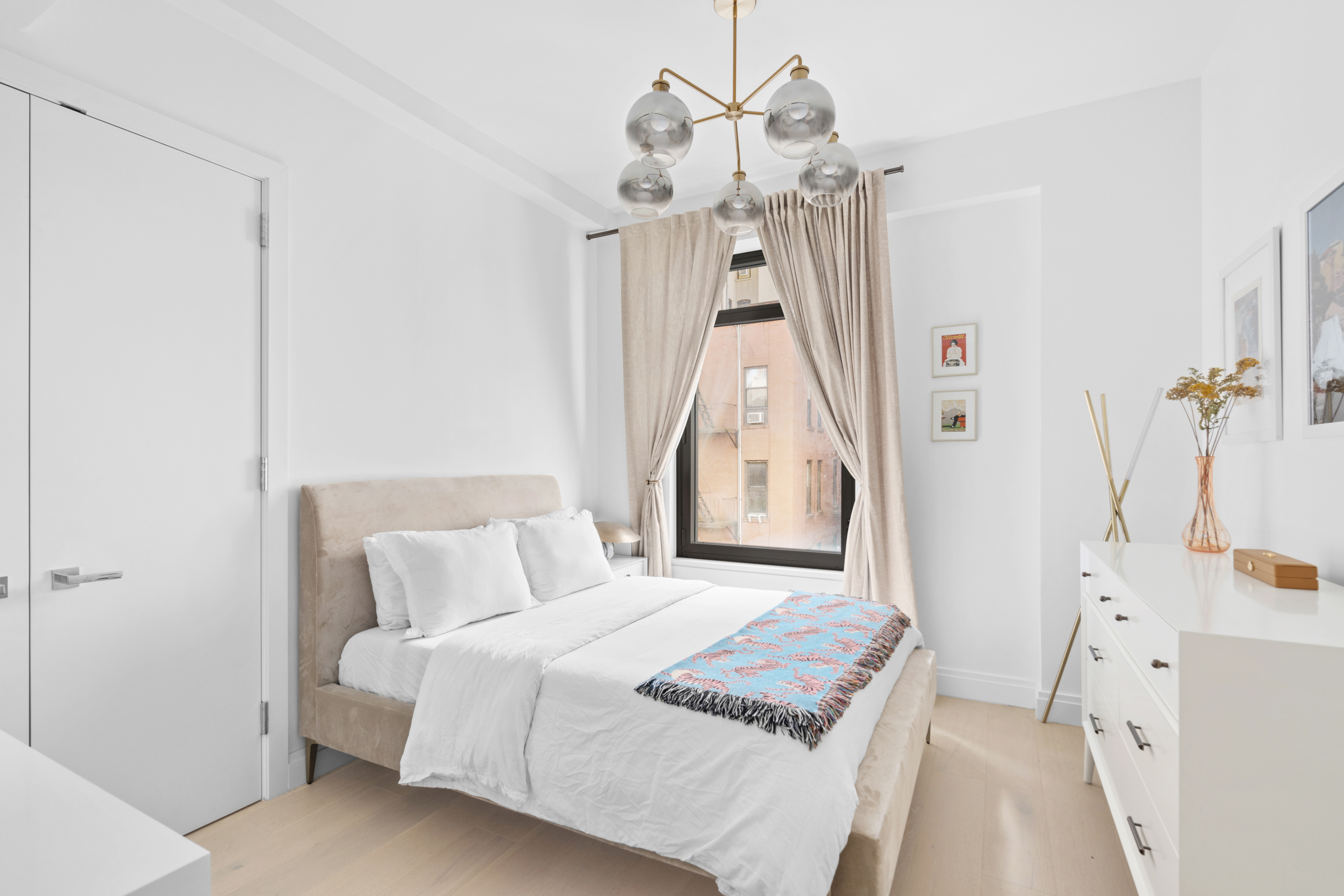 212 West 95th Street, Unit 4A Manhattan, NY 10025 - Photo 7 of 13 a bedroom with a bed and a chandelier