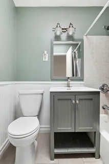 a bathroom with a toilet a sink and mirror