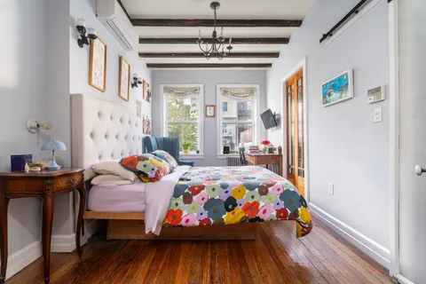 a bedroom with baby bed and a window