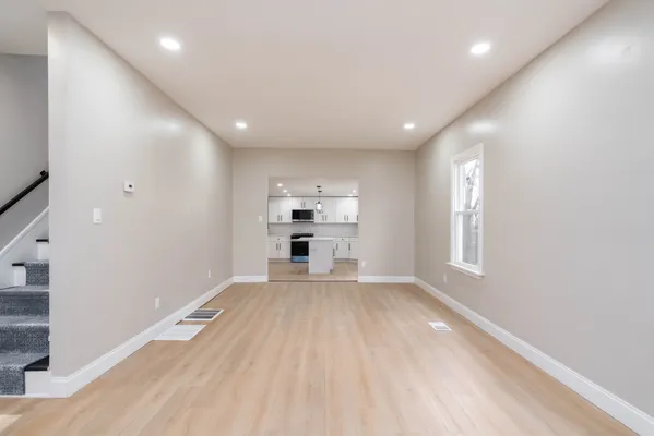a view of empty room with wooden floor and window