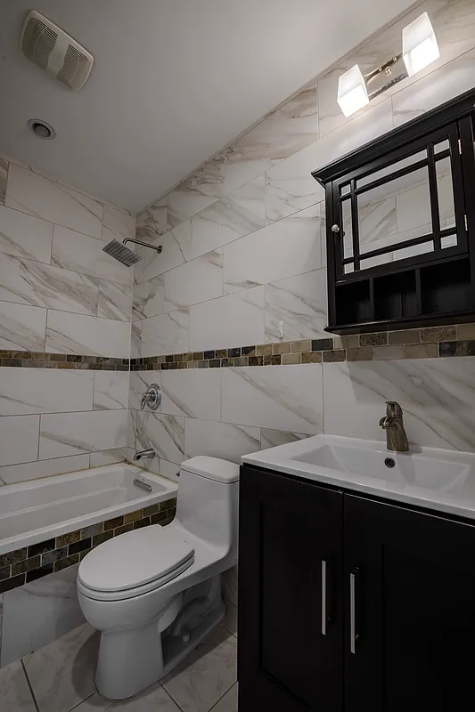 877 Greene Avenue, Unit 2 Brooklyn, NY 11221 - Photo 7 of 13 a bathroom with a sink a toilet and mirror
