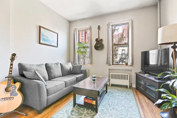 a living room with furniture a flat screen tv and a window