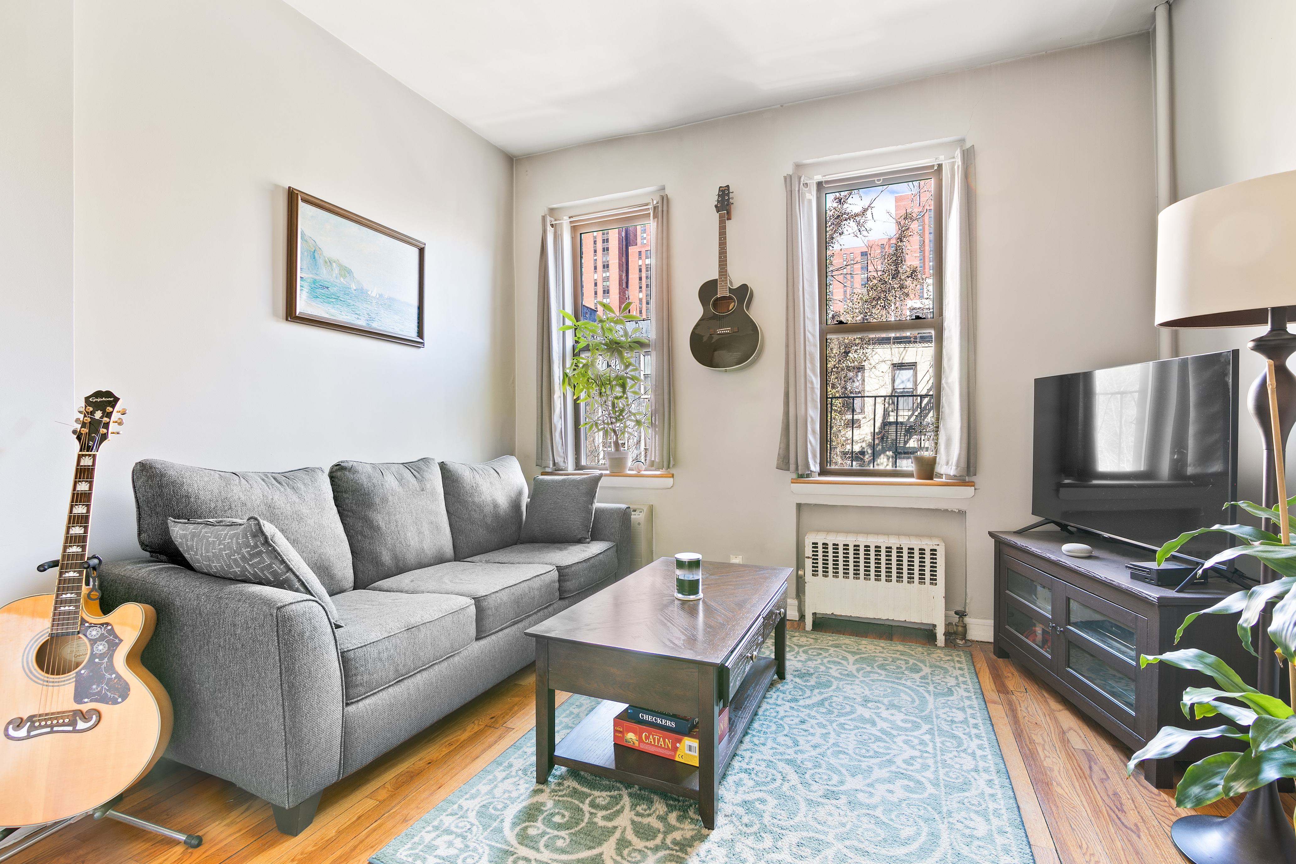 a living room with furniture a flat screen tv and a window