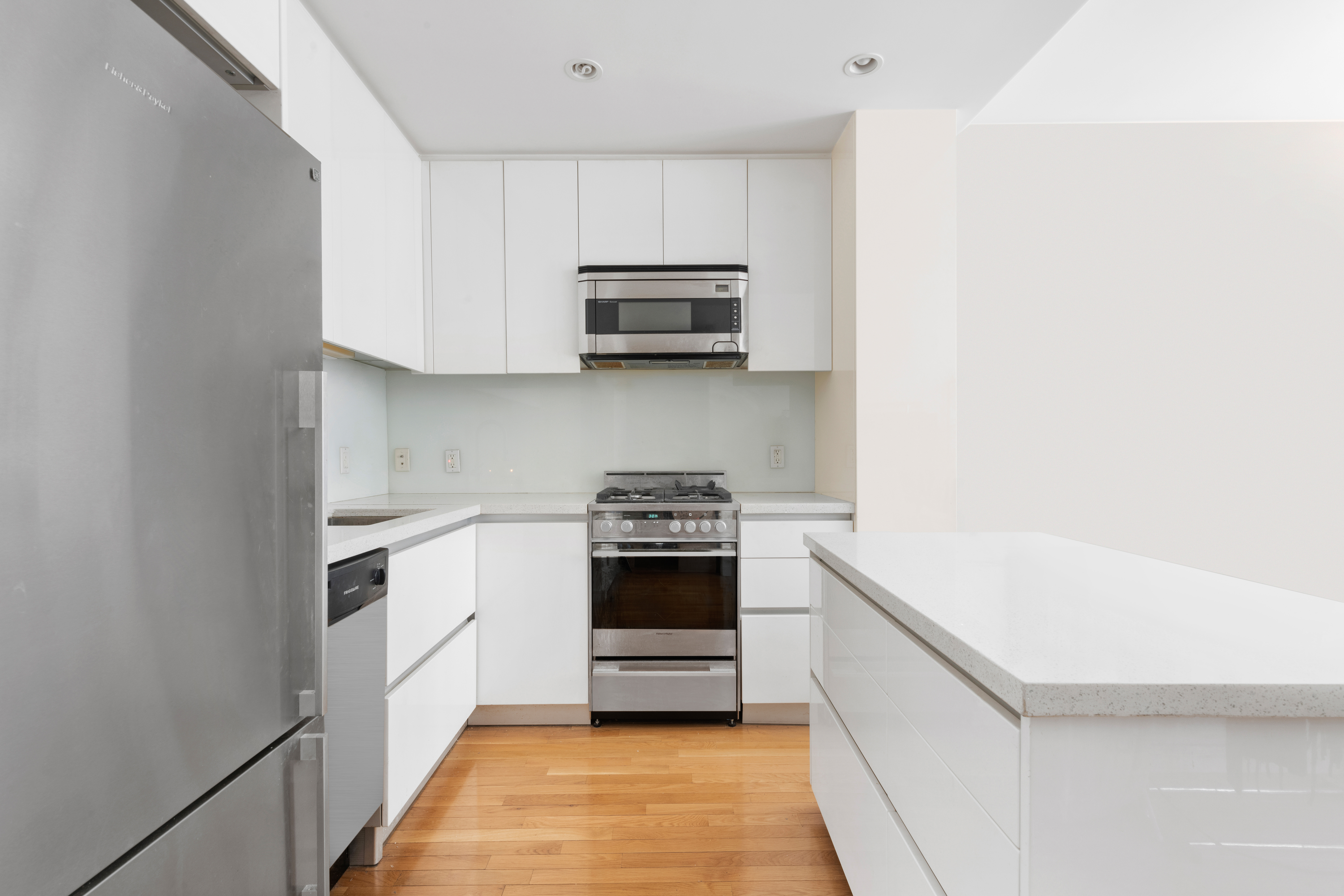 148 East 24th Street, Unit 12B Manhattan, NY 10010 - Photo 3 of 13 a kitchen with stainless steel appliances granite countertop white cabinets and a stove