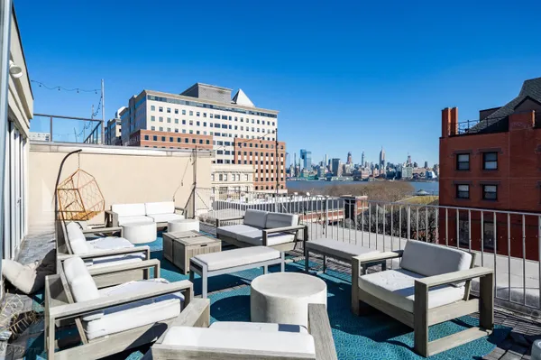 a roof deck with couches and wooden floor