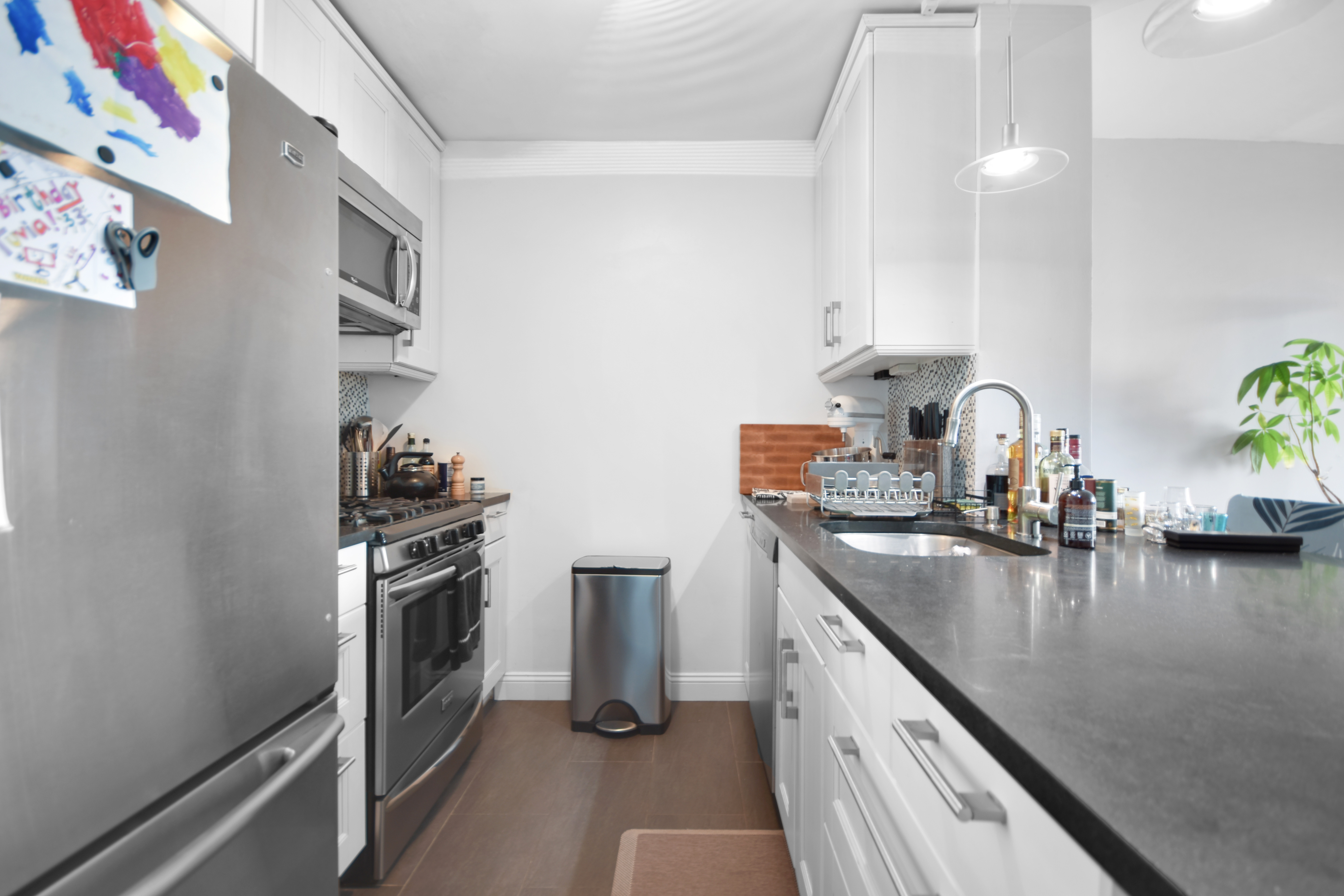 4-74 48th Avenue, Unit 34G Queens, NY 11109 - Photo 5 of 9 a kitchen with sink a stove and refrigerator