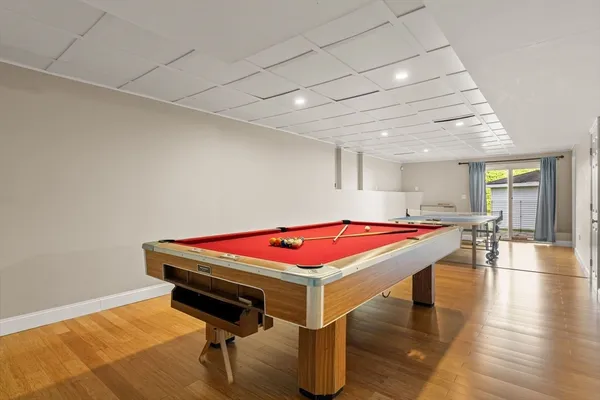 a room with pool table and wooden floor