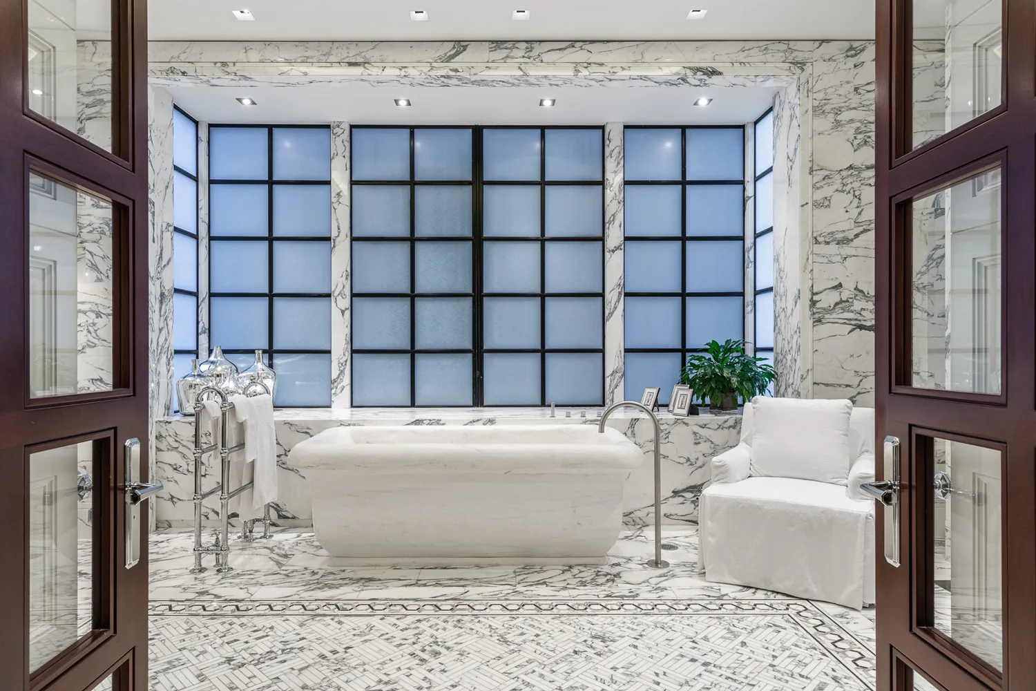 a large spacious bathroom with a tub and chandelier