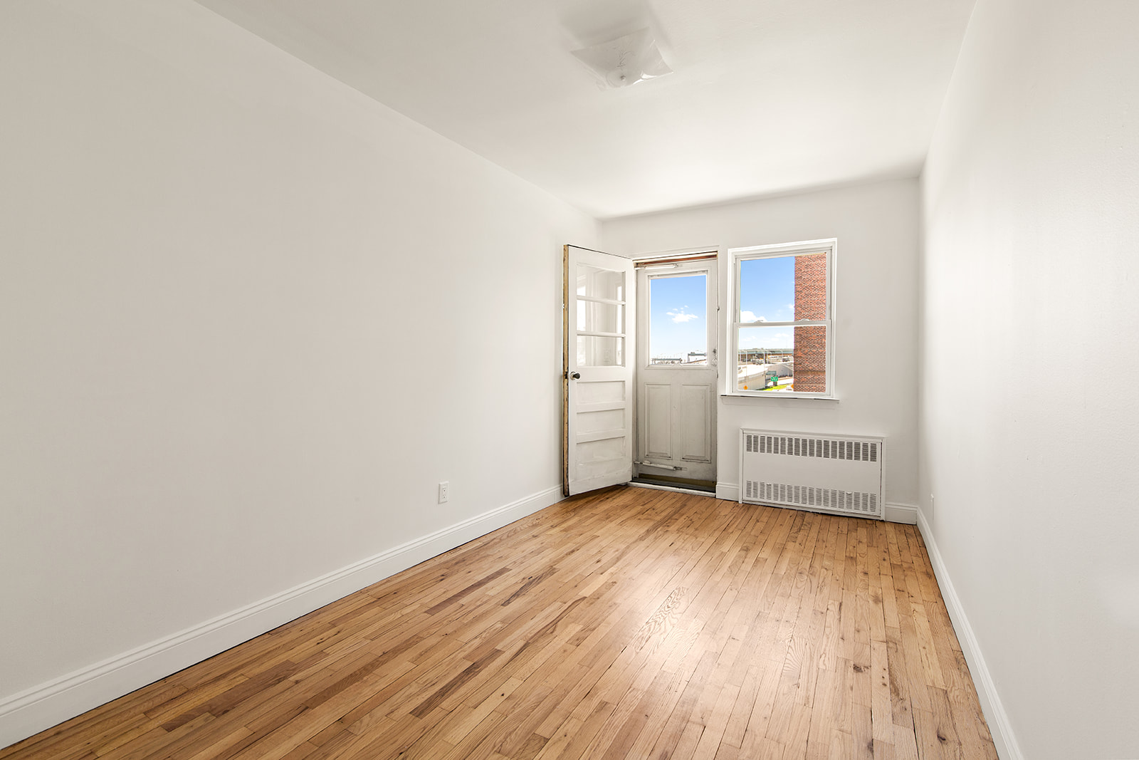 572 92nd Street Brooklyn, NY 11209 - Photo 9 of 20 a view of a room with wooden floor and white walls