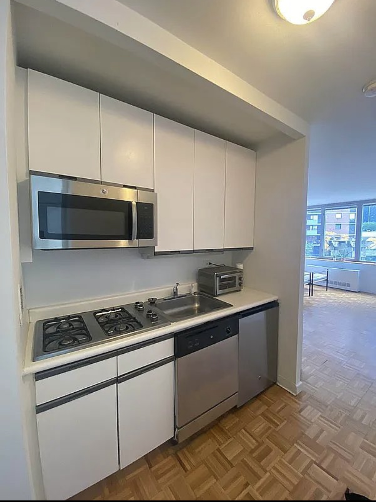 500 West 43rd Street, Unit 4E Manhattan, NY 10036 - Photo 3 of 11 a kitchen with stainless steel appliances granite countertop a sink and a stove