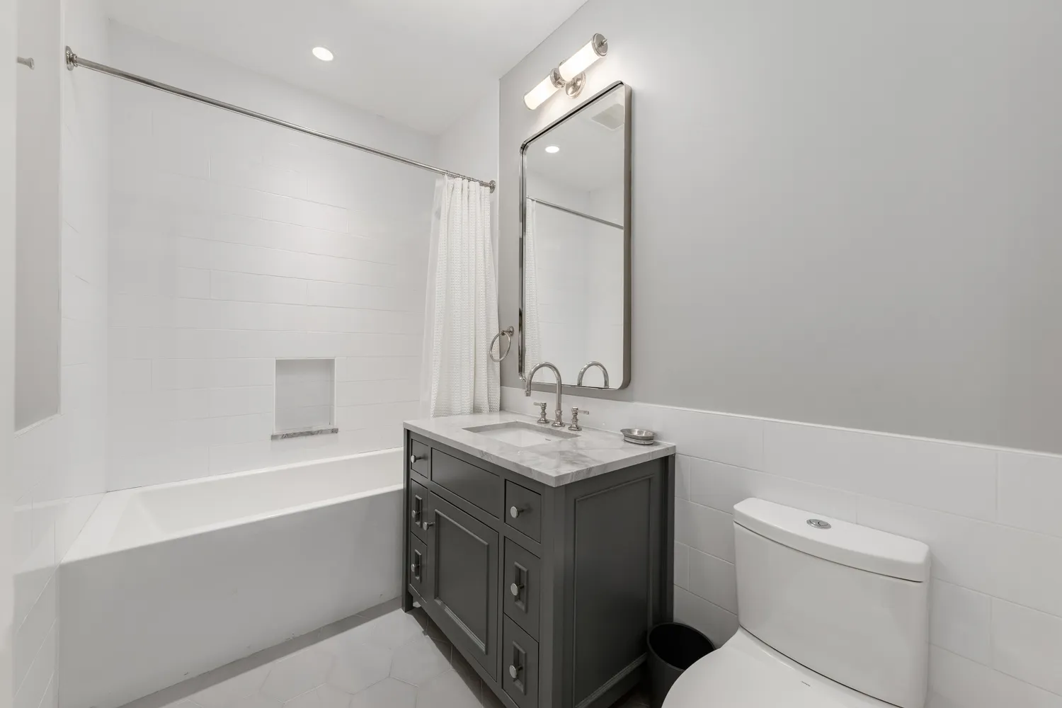 a bathroom with a granite countertop sink a toilet and a bathtub