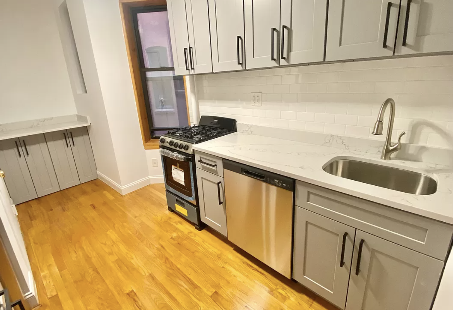 314 East 11th Street, Unit 3B Manhattan, NY 10003 - Photo 3 of 11 a kitchen with stainless steel appliances granite countertop a sink stove and cabinets
