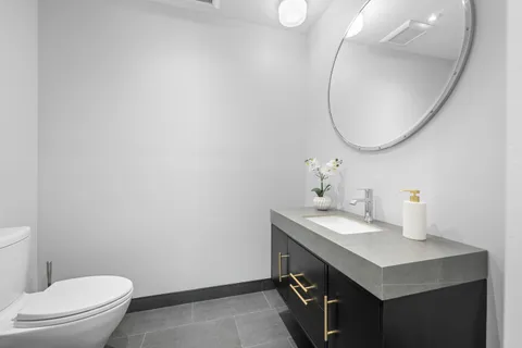 a bathroom with a sink a toilet and a mirror