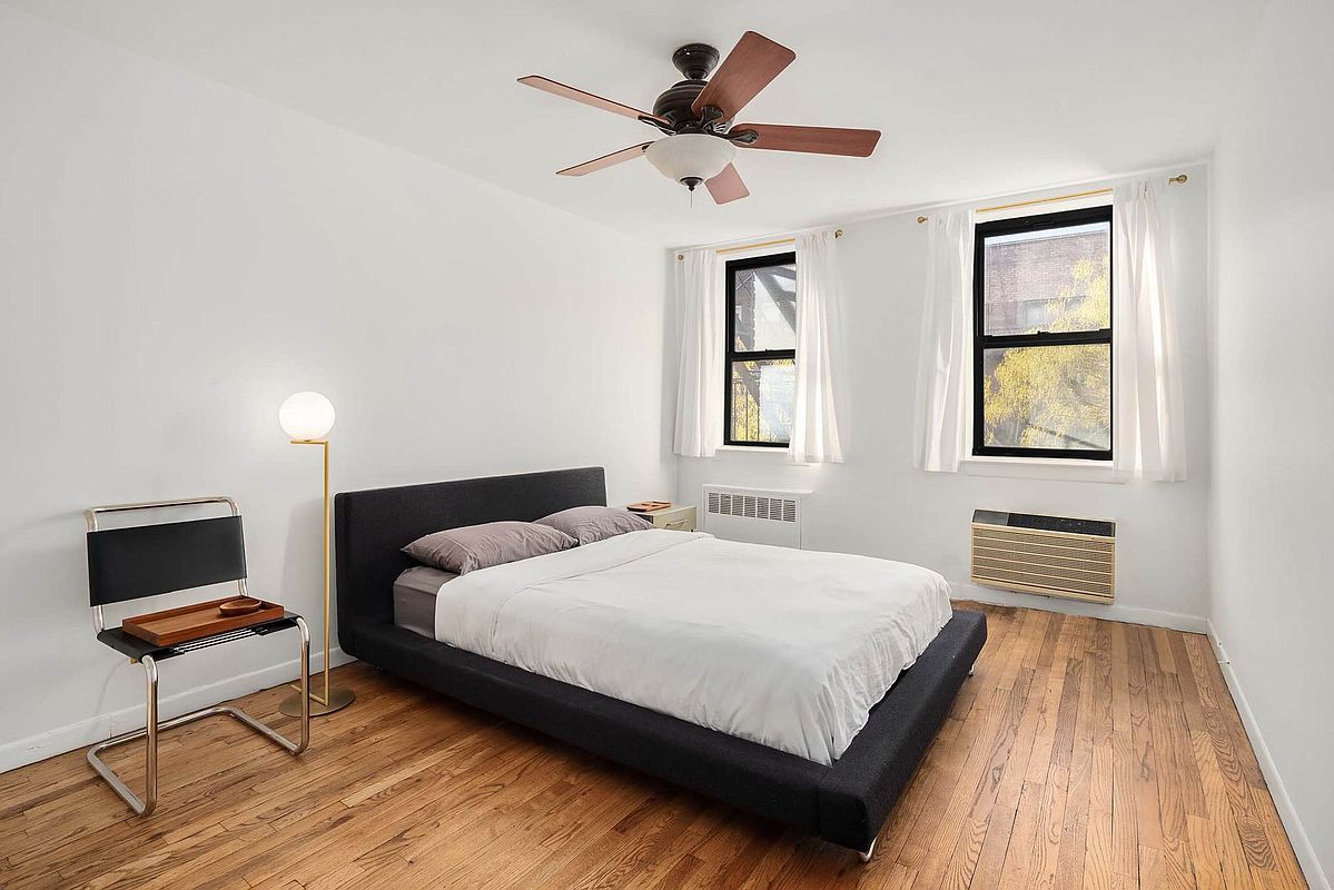 215 East 77th Street, Unit 4C Manhattan, NY 10075 - Photo 5 of 7 a bedroom with a bed and a flat screen tv