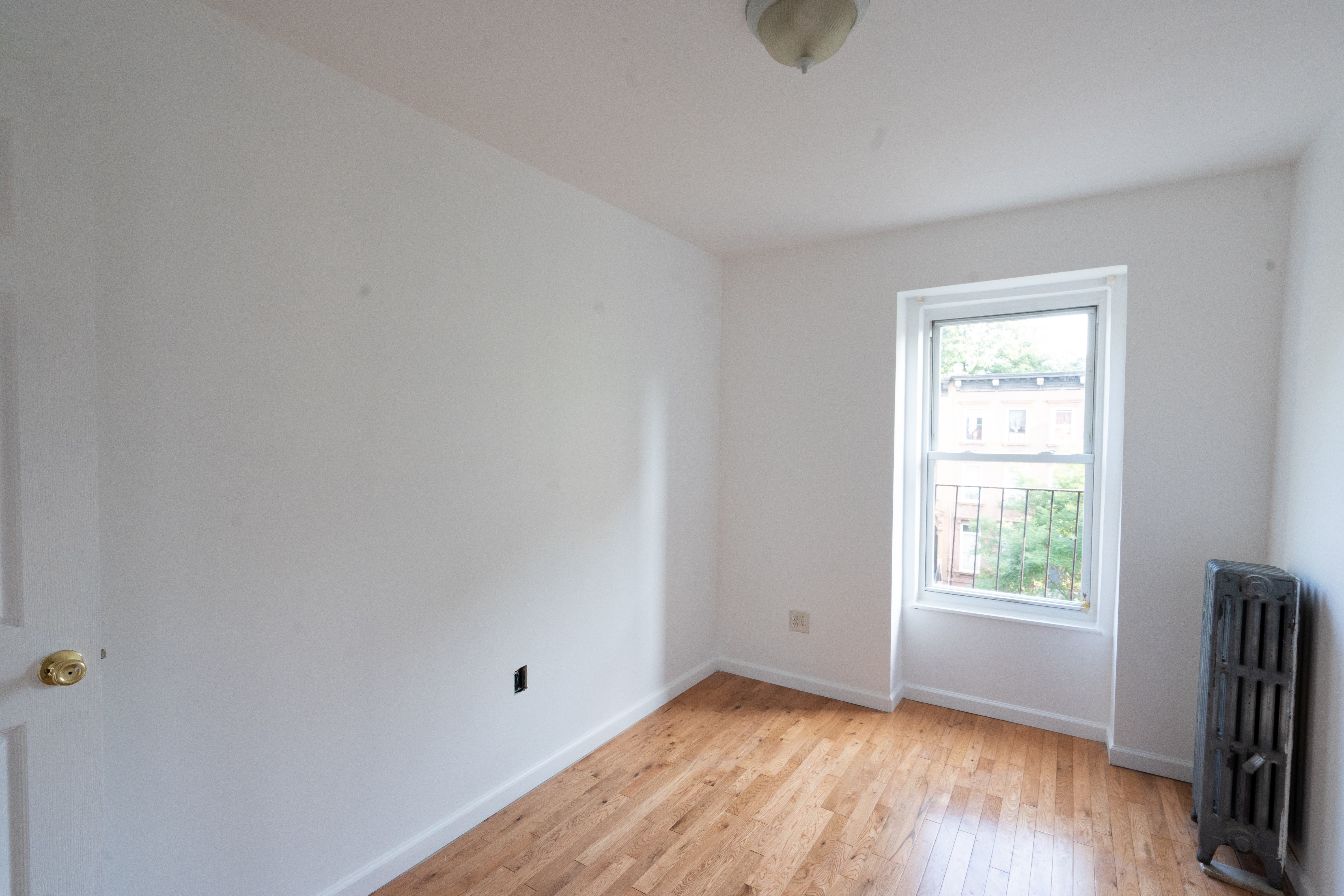 1379 Pacific Street, Unit 4 Brooklyn, NY 11216 - Photo 2 of 8 a view of an empty room with wooden floor and a window
