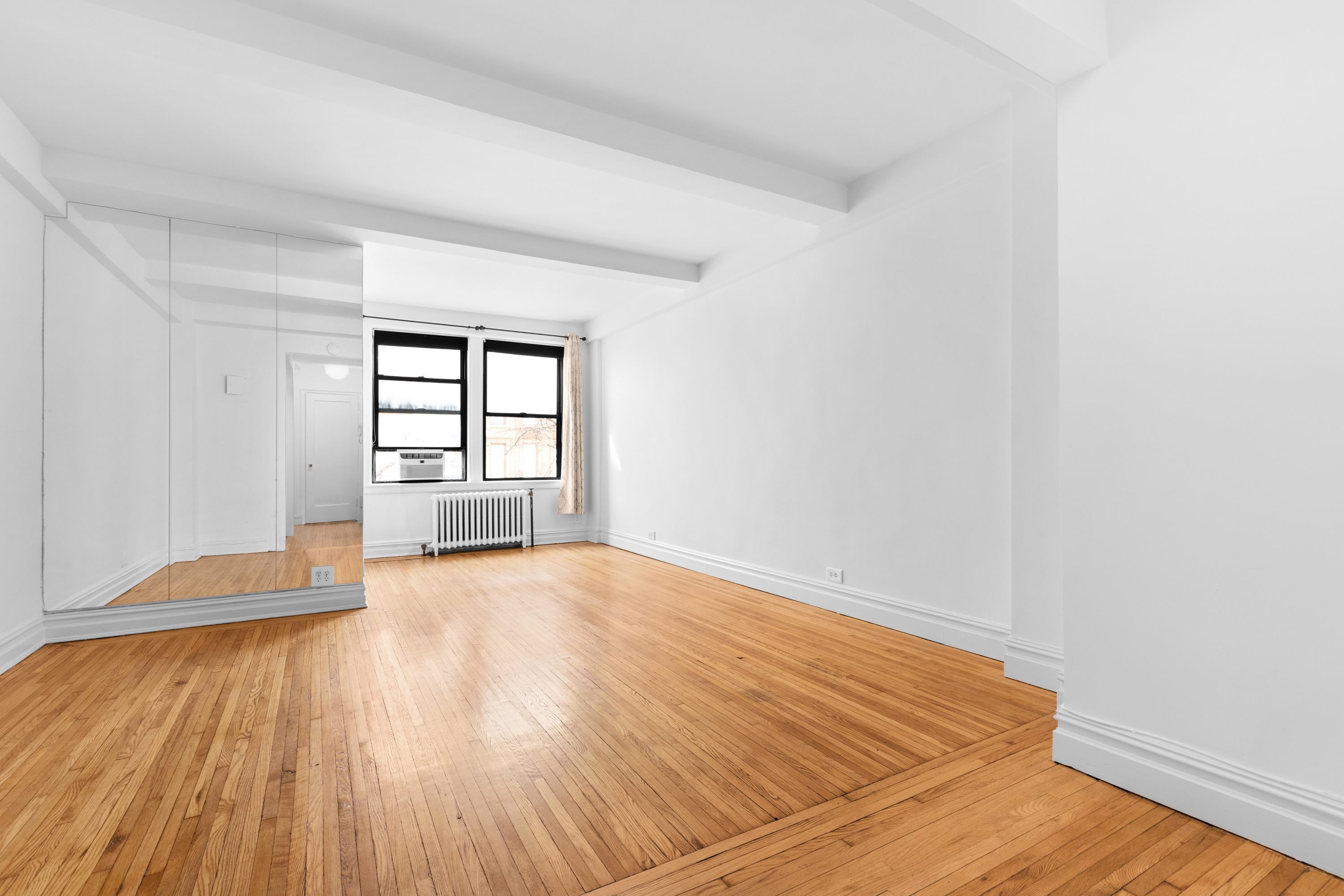 457 West 57th Street, Unit 304 Manhattan, NY 10019 - Photo 2 of 7 wooden floor in an empty room with a window