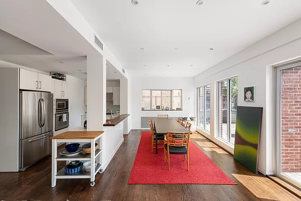 210 West 16th Street, Unit PH Manhattan, NY 10011 - Photo 2 of 16 a living room with furniture a flat screen tv and a refrigerator