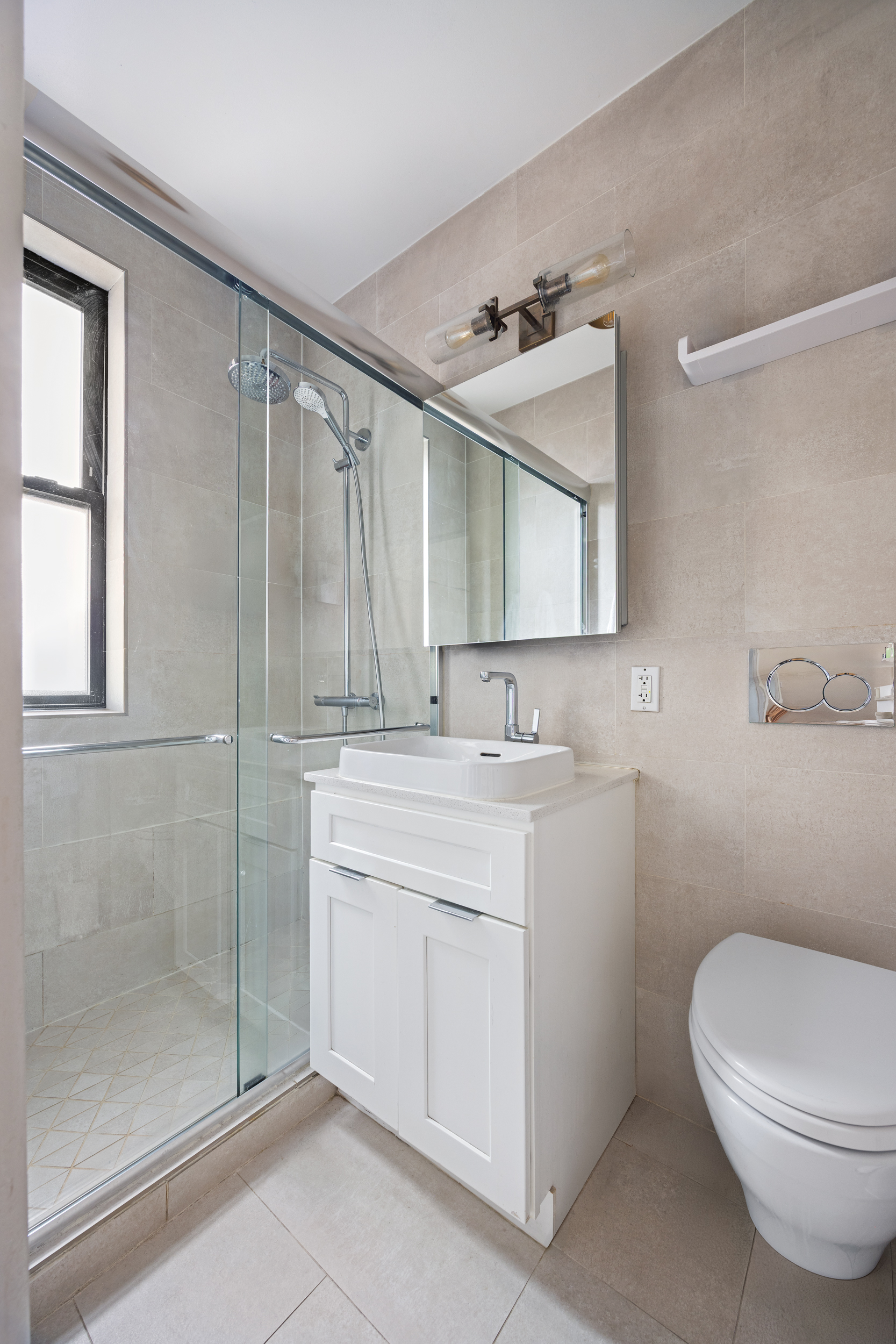 342 West 21st Street, Unit 4B Manhattan, NY 10011 - Photo 8 of 9 a bathroom with a sink a toilet and shower