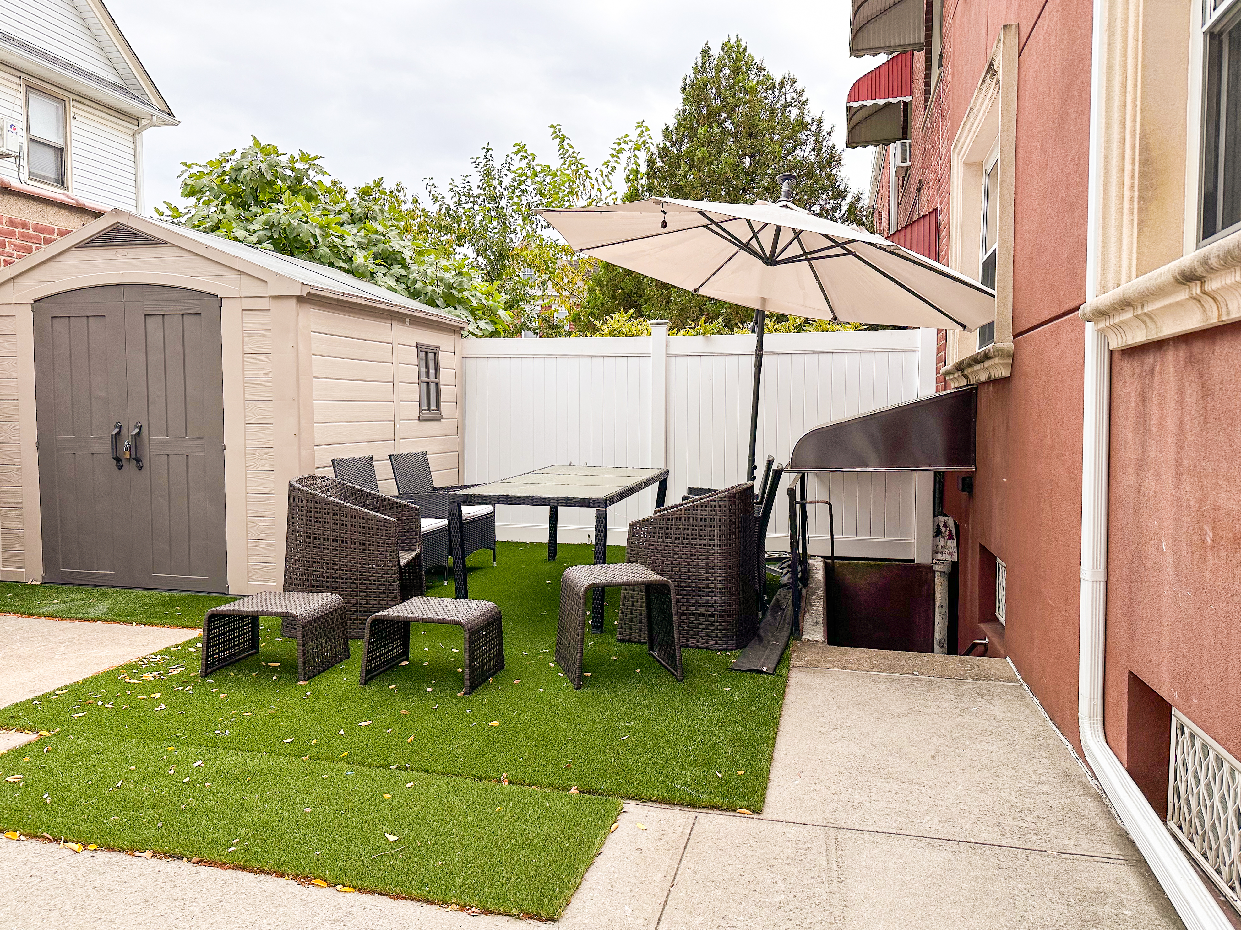 10-01 154th Street, Unit 1 Queens, NY 11357 - Photo 9 of 10 a backyard of a house with barbeque oven table and chairs