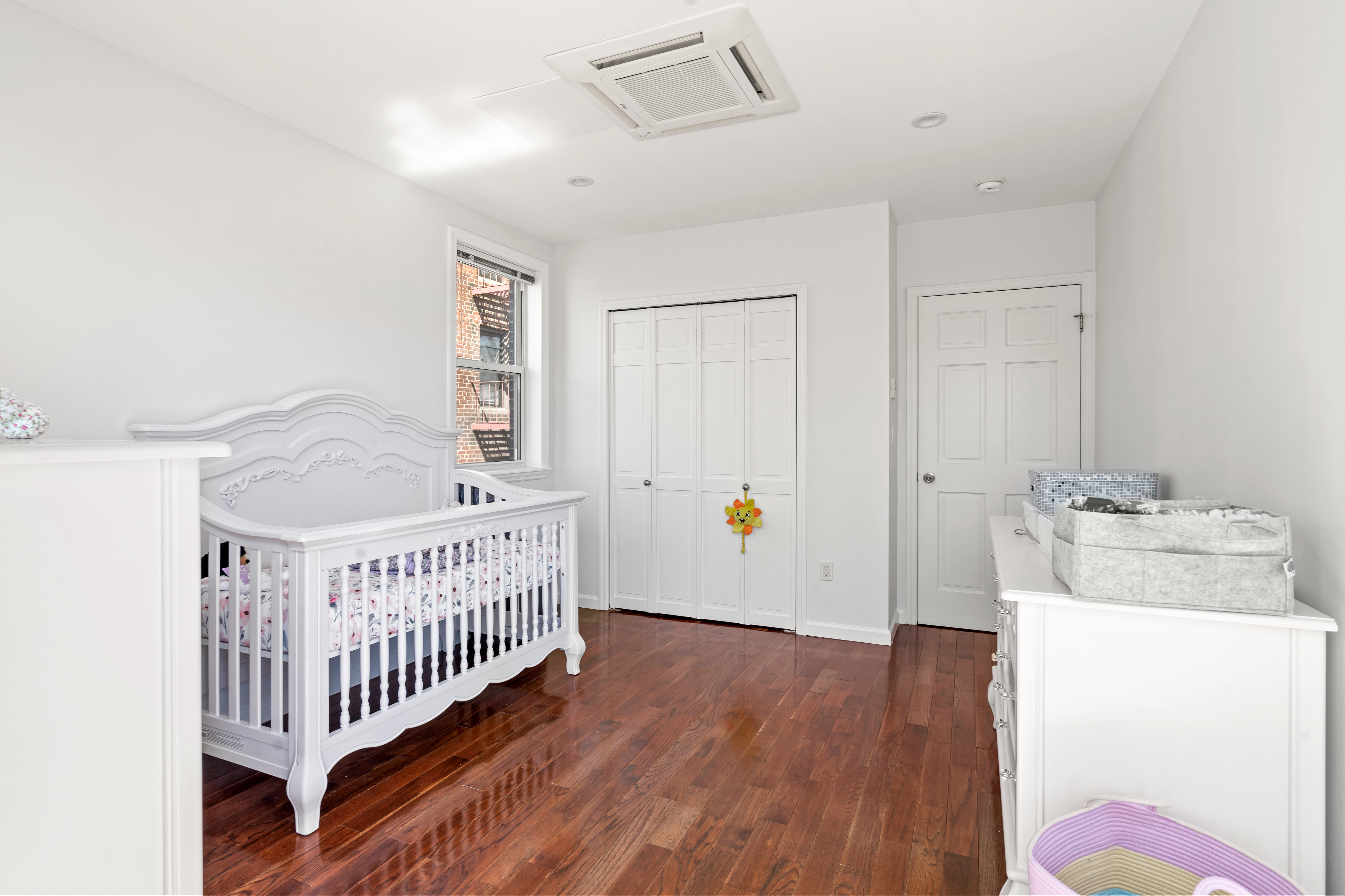 65-33 38th Avenue, Unit 5 Queens, NY 11377 - Photo 14 of 23 a bedroom with furniture and baby crib