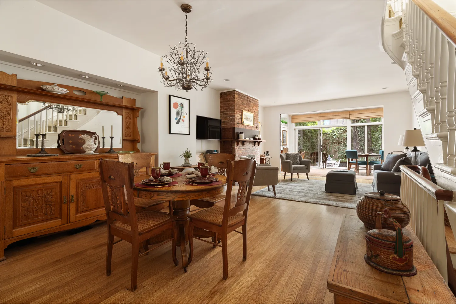 a view of a dining room and livingroom with furniture wooden floor a chandelier