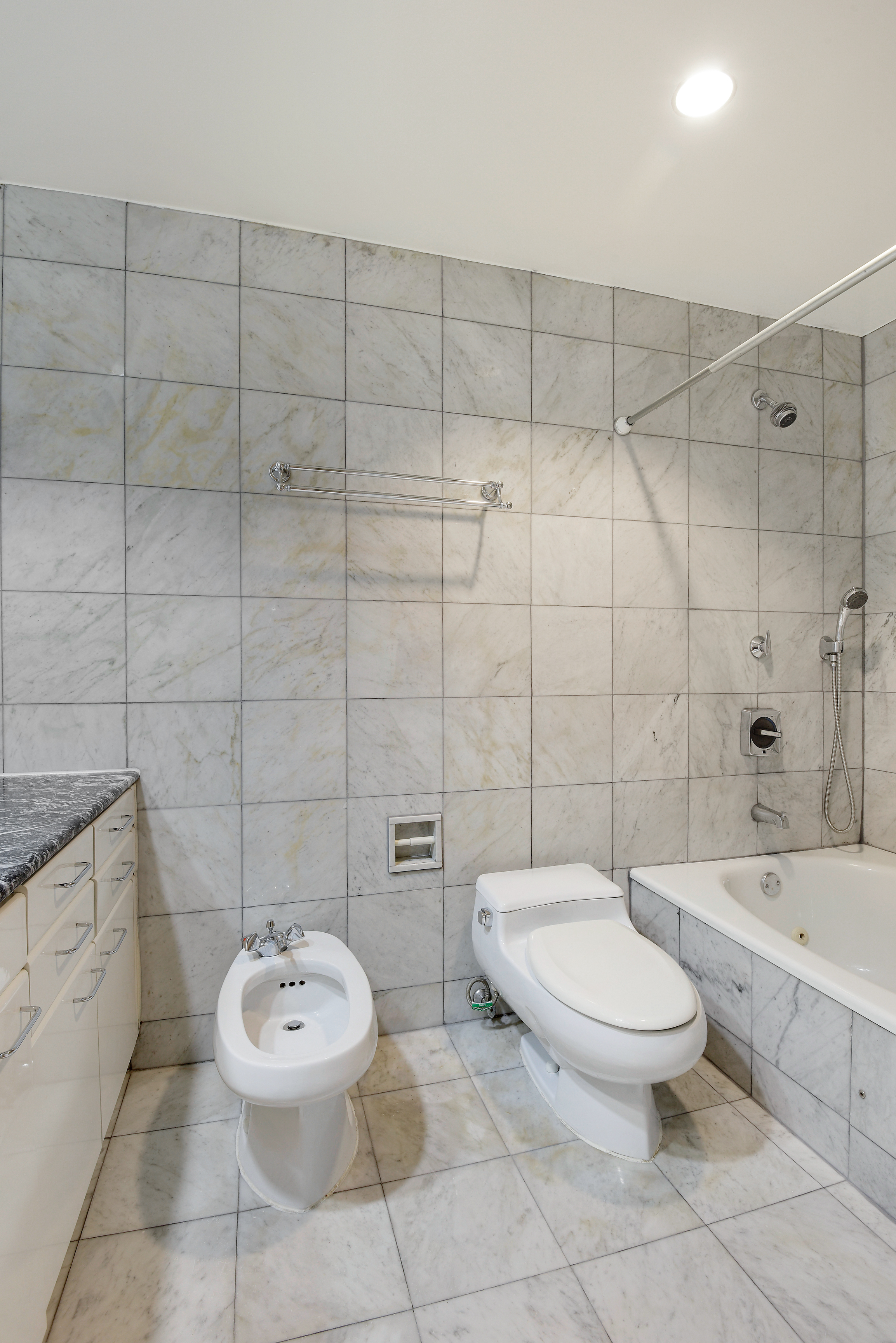 146 West 57th Street, Unit 38E Manhattan, NY 10019 - Photo 6 of 16 a bathroom with a toilet sink and shower