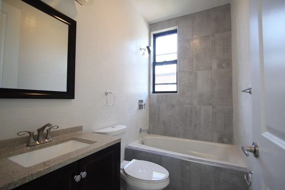 186 Howard Avenue Brooklyn, NY 11233 - Photo 8 of 14 a bathroom with a granite countertop sink toilet and shower
