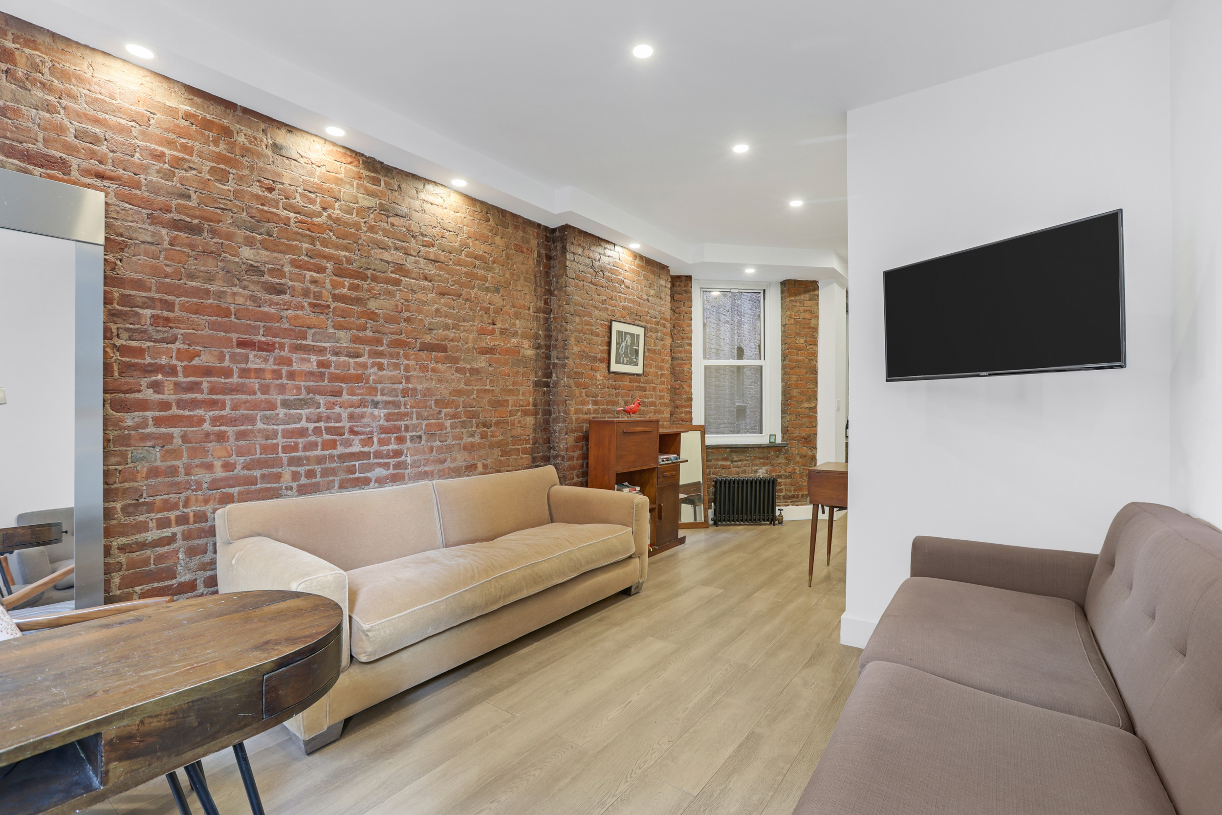 252 East 7th Street, Unit 7/8 Manhattan, NY 10009 - Photo 2 of 13 a living room with furniture and a flat screen tv