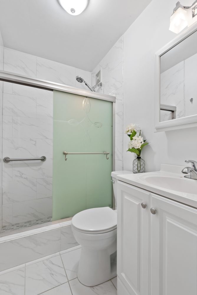 18-91 Stockholm Street, Unit 1 Queens, NY 11385 - Photo 4 of 5 a bathroom with a sink a toilet and shower