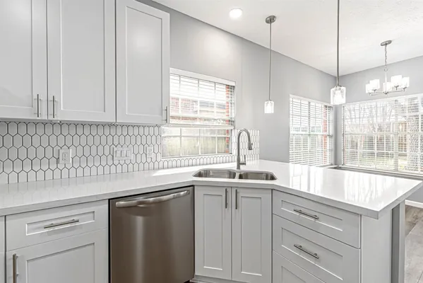 a kitchen with stainless steel appliances granite countertop a sink a window and cabinets