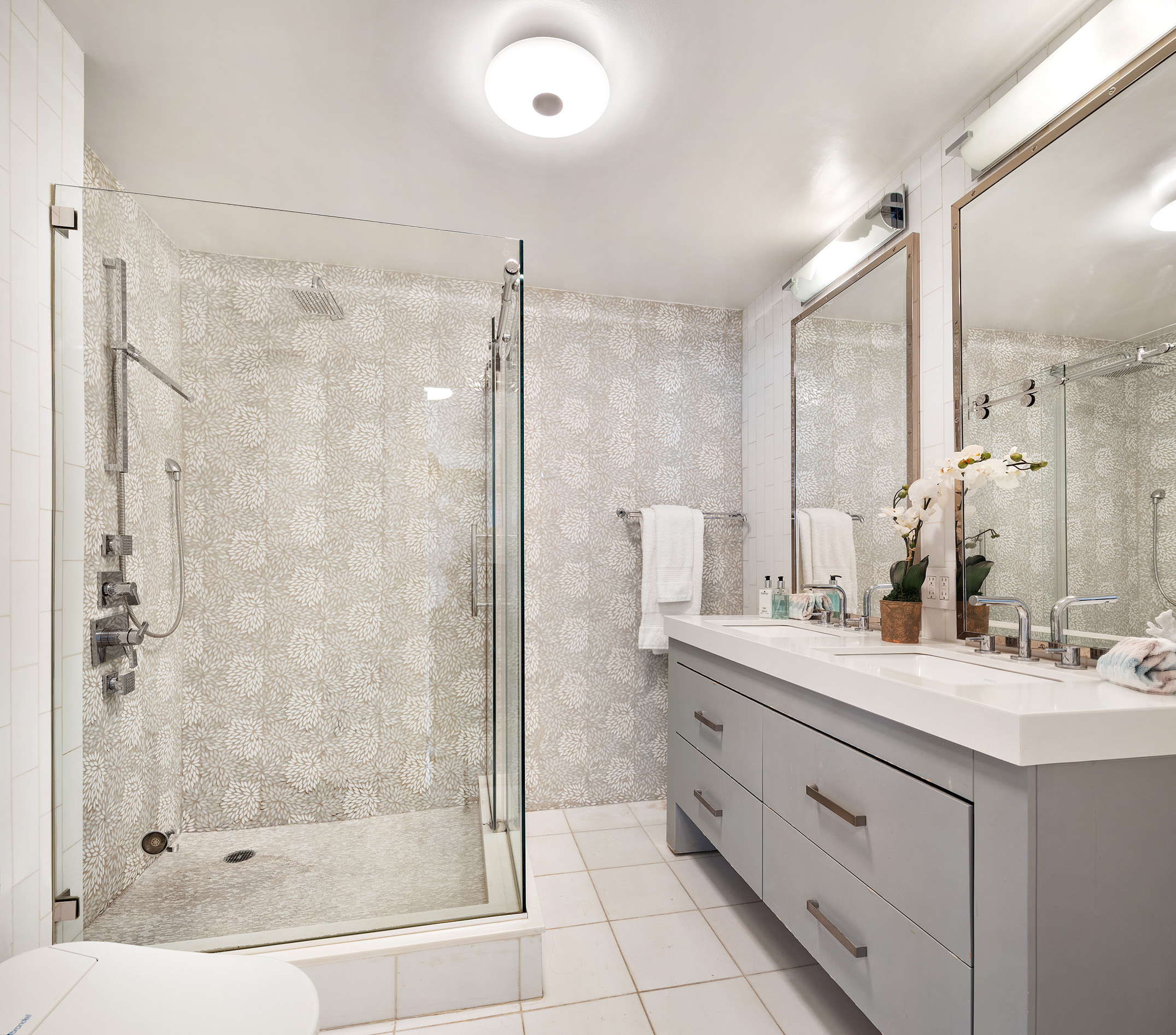 155 East 38th Street, Unit 12K Manhattan, NY 10016 - Photo 9 of 15 a bathroom with a double vanity sink mirror and shower
