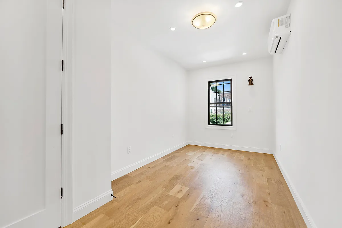 297 Howard Avenue, Unit 2 Brooklyn, NY 11233 - Photo 5 of 13 wooden floor in an empty room with a window
