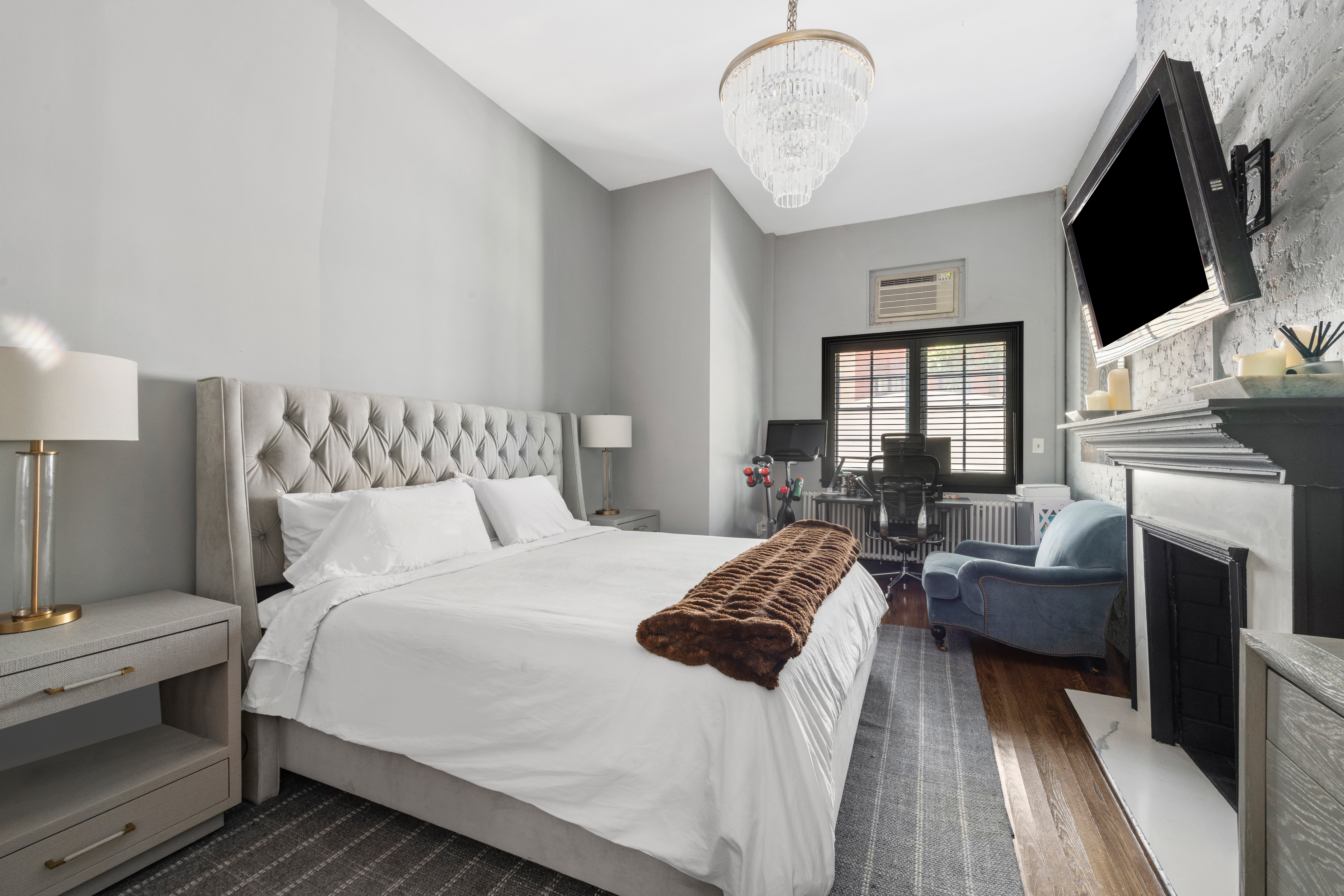 21 West 9th Street, Unit 1F Manhattan, NY 10011 - Photo 5 of 11 a bedroom with a bed a flat screen tv and couches