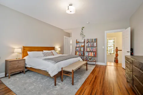 a bedroom with a bed and wooden floor