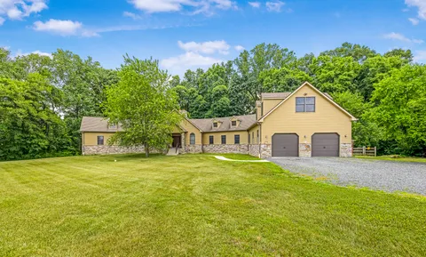 a front view of house with yard and trees in the background