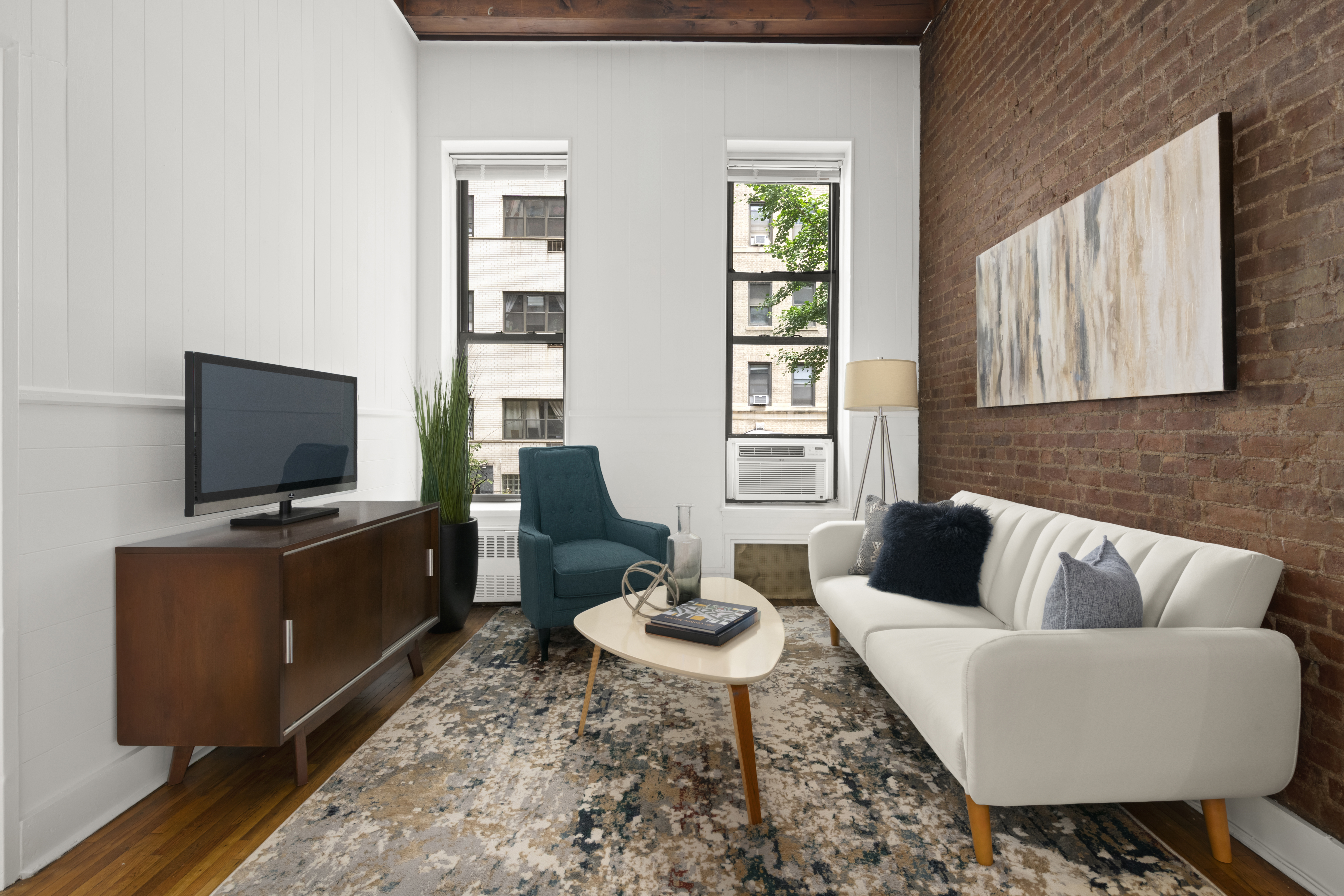 132 West 71st Street, Unit 3 Manhattan, NY 10023 - Photo 3 of 7 a living room with furniture and a flat screen tv