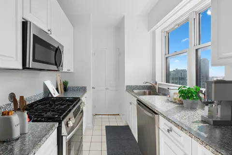 a kitchen with stainless steel appliances granite countertop a sink stove and microwave