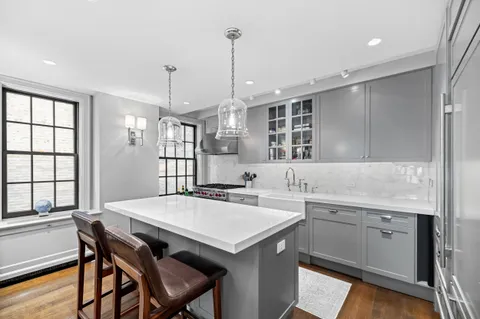a kitchen with a dining table chairs sink and cabinets