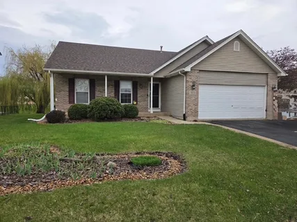 a front view of a house with a garden and yard