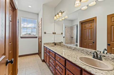 a bedroom with a bed a flat screen tv and a window