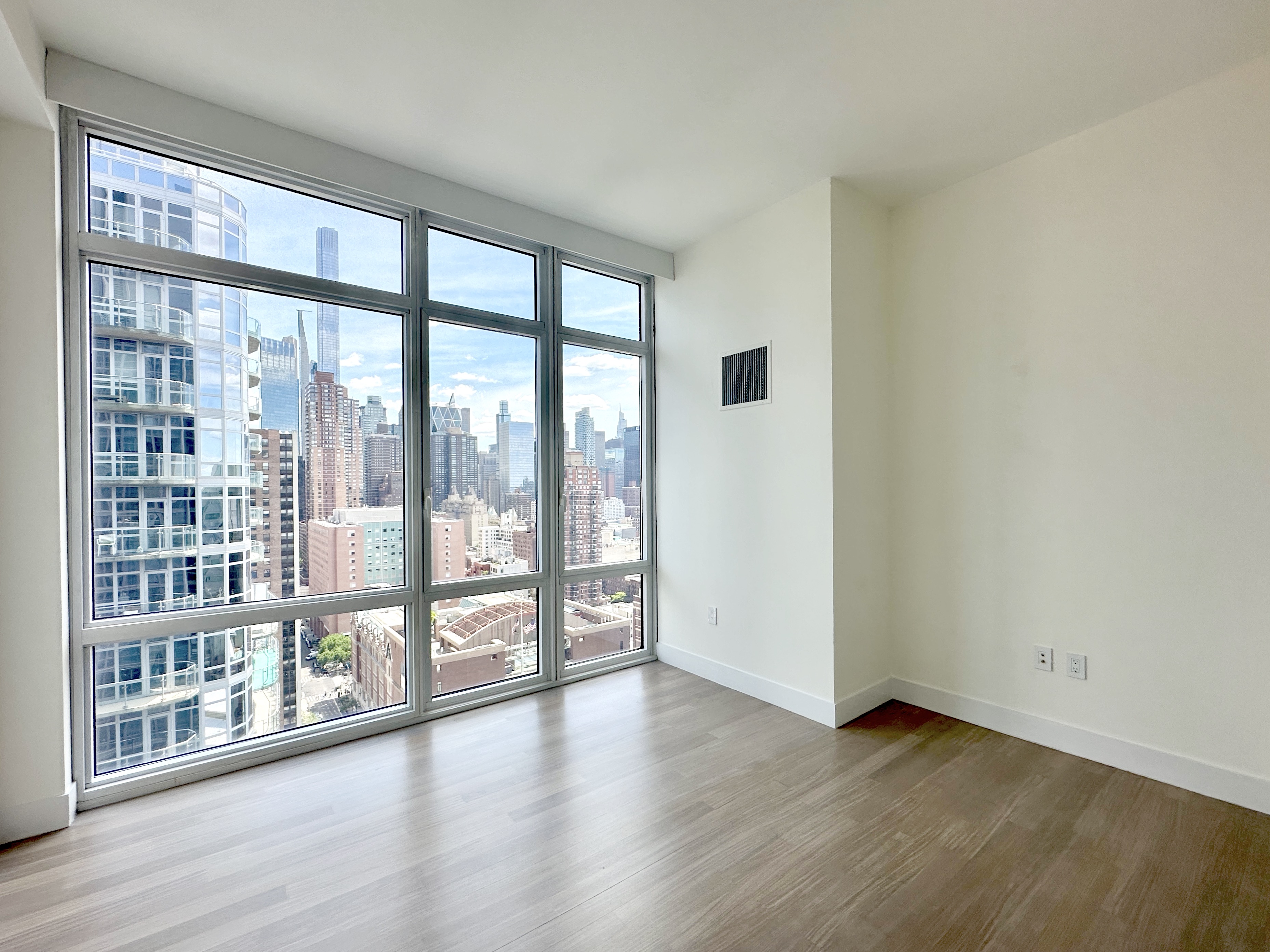 10 West End Avenue, Unit 30C Manhattan, NY 10023 - Photo 15 of 22 a view of an empty room with wooden floor and a window