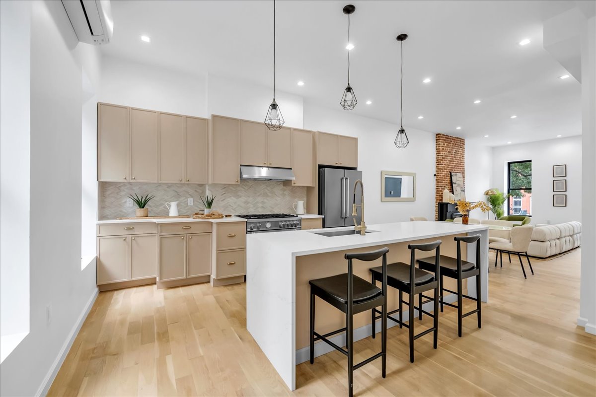 448 Halsey Street, Unit 1 Brooklyn, NY 11233 - Photo 9 of 22 a kitchen with white cabinets stainless steel appliances and kitchen island