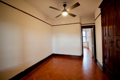 an empty room with wooden floor and a window