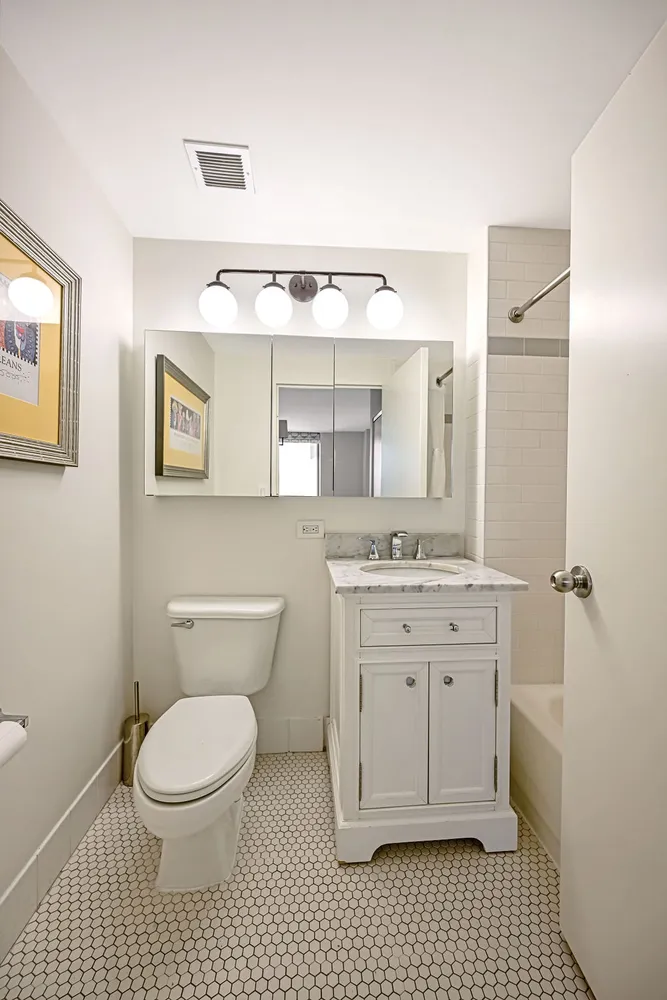 a bathroom with a granite countertop toilet sink and a mirror