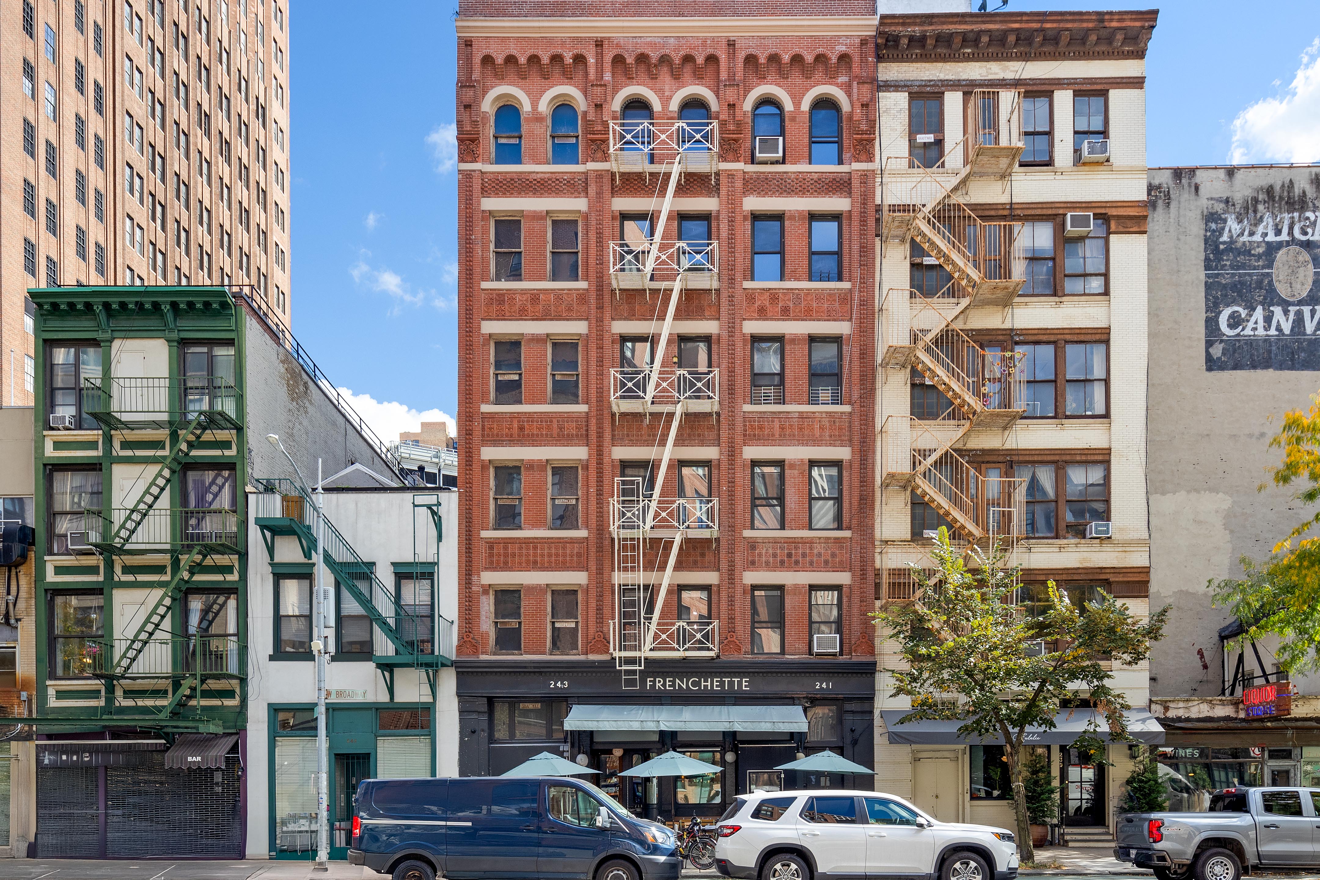 243 West Broadway, Unit 4 Manhattan, NY 10013 - Photo 12 of 14 a front view of a building with a lot of cars and trees