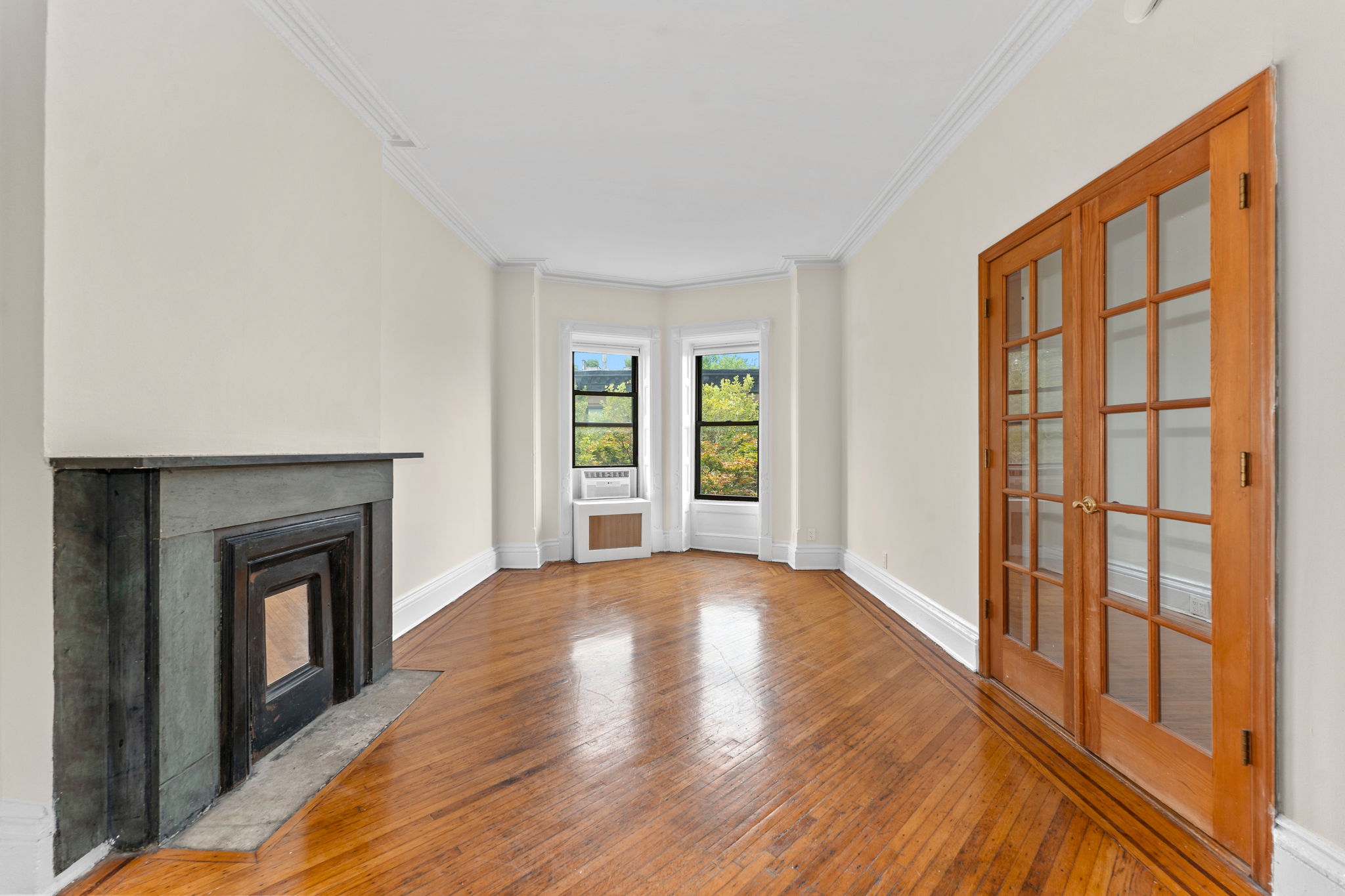 a view of an empty room with window and fire place