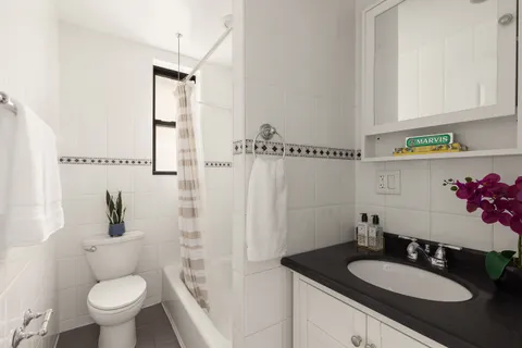 a bathroom with a granite countertop sink toilet a mirror and shower