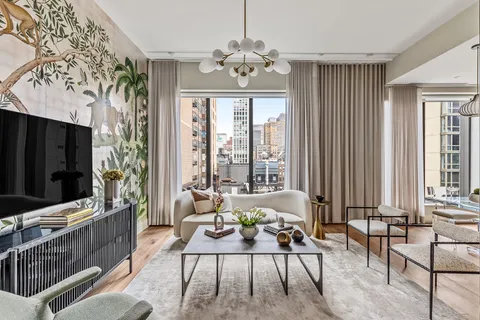 a living room with patio furniture and a flat screen tv
