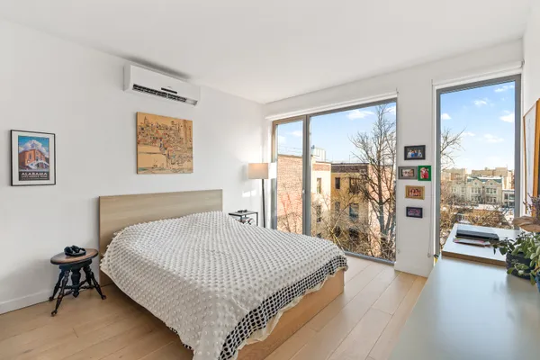 a bedroom with a bed and a large window