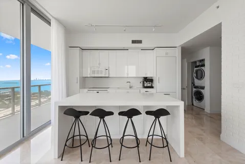 a kitchen with stainless steel appliances a table and chairs in it